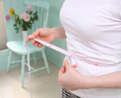 ウエストをはかる女性